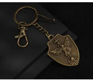 Vintage bronze shield keychain featuring angel warrior and Latin cross design for bags and keys.