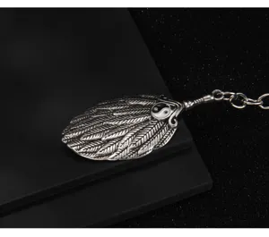 Close-up detail of vintage Chinese style Yin Yang fan metal keychain pendant texture.