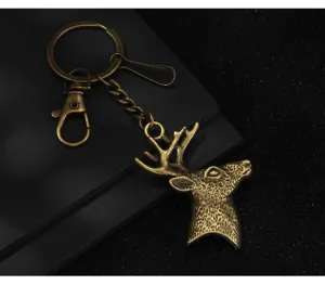 Gros plan détaillé d'un porte-clés tête de cerf en métal bronze antique avec anneau.