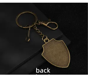 Vintage bronze shield keychain with lobster clasp and split ring for bags and keys.