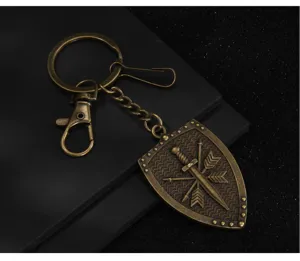 Detailed close-up view of a vintage bronze shield sword keychain accessory with metal ring.
