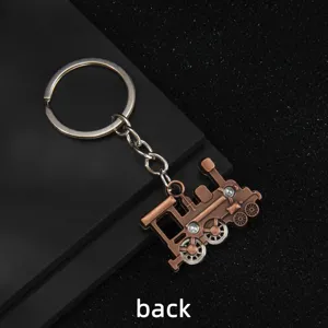 Vintage locomotive keychain with movable wheels, retro metal model car bag pendant.