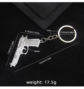 Detail of silver metal pistol keychain showing dimensions, alloy body, and iron ring.