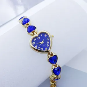 Women's heart-shaped quartz watch with blue crystal bracelet and gold-tone metal case.
