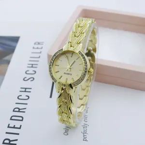 Elegant gold quartz watch with rhinestone bezel and leaf metal strap for women fashion style.