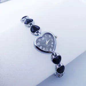 Close-up of elegant heart-shaped quartz watch with stylish black crystal links and silver finish.