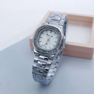 Detail shot of women square rhinestone watch dial and steel strap, close-up view.