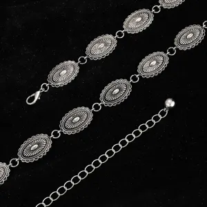 Gros plan détaillé d'une ceinture chaîne en métal argenté vintage aux médaillons ovales.