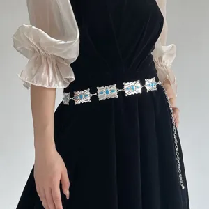 Détail en gros plan de la chaîne de taille bohème vintage avec des maillons floraux bleus.
