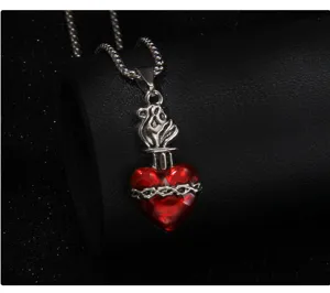 Gros plan sur le collier pendentif cœur rouge gothique, chaîne en acier inoxydable fin.