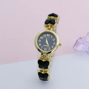 Women gold quartz wristwatch featuring black butterfly links and round dial detail.