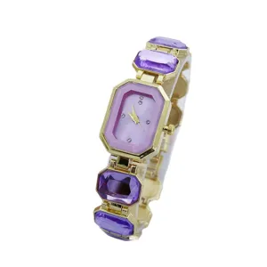 Elegante goudkleurige dames quartz horloge met paarse edelsteen bezel en armband.