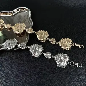 Primer plano de los eslabones de cadena con textura metálica, acabados en oro y plata.