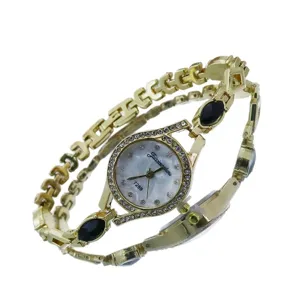 Élégante montre bracelet quartz dorée pour femme avec strass étincelants et pierres bleues.