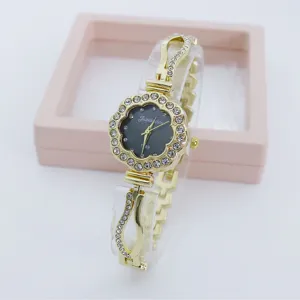 Detailed close-up view of the rhinestone flower dial quartz women watch with gold metal band.