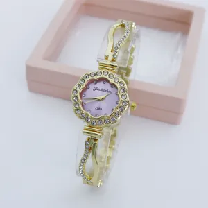 Detail view of the elegant rhinestone flower quartz watch with a pink dial and gold chain strap.