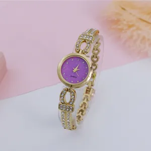 Women fashion rhinestone quartz bracelet watch with purple glitter dial and gold strap detail.