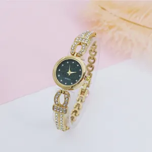 Close-up detail of women's gold quartz watch featuring starry dial and sparkling rhinestones.