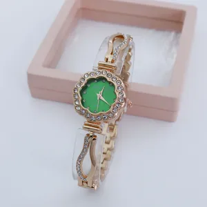 Elegant rhinestone flower dial quartz women watch with green face and chic bracelet strap.