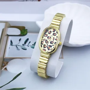 Vista detallada del reloj de cuarzo ovalado con esfera de leopardo y brazalete dorado.