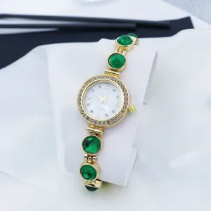 Close-up detail van luxe dames quartz horloge met groene stenen en schitterende strass.