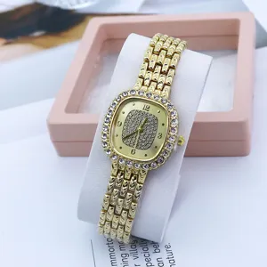 Close-up detail of the elegant square rhinestone gold quartz watch with shiny crystal bezel.