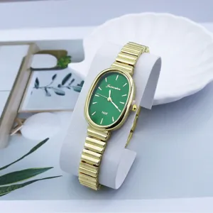 Vista detallada del reloj de cuarzo dorado para mujer con esfera verde ovalada y pulsera.