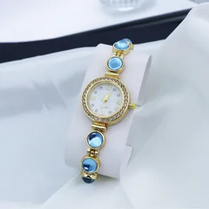 Elegante dames quartz horloge met blauwe kralen armband en sprankelende strass wijzerplaat.