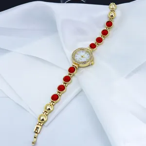 Dames goudkleurige quartz horloge met rode kralen armband en strass stenen wijzerplaat.