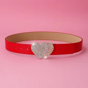 Gros plan sur la boucle étincelante à double cœur en strass d'une ceinture pour femme.