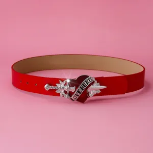 Detailopname van de punk rode lederen riem met zilveren hart en dolk gesp accessoire.