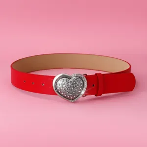 Ceinture femme en cuir PU rouge avec boucle strassée en forme de cœur pour les détails.