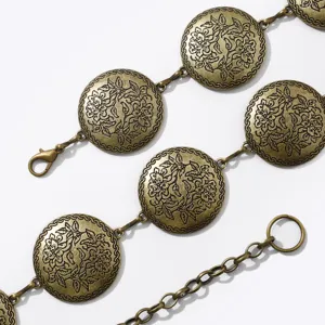 Vue détaillée des médaillons métalliques sculptés floraux en bronze pour la chaîne de taille.