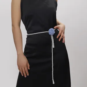Nahaufnahme der eleganten Perlen-Taillenkette mit blauer Stoffrose und langem Perlenanhänger.