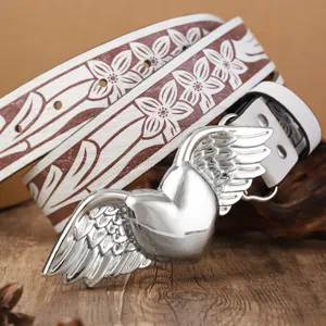 Cinturón de cuero PU con relieve floral blanco retro y llamativa hebilla de corazón con alas.