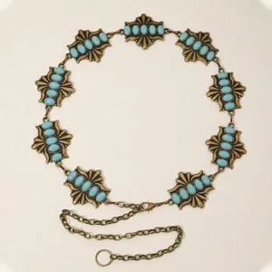 Gros plan sur les details de la chaine de taille en metal avec des pierres turquoise.