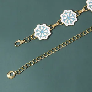 Detalle de cadena metálica dorada con dijes de copo de nieve de esmalte blanco.