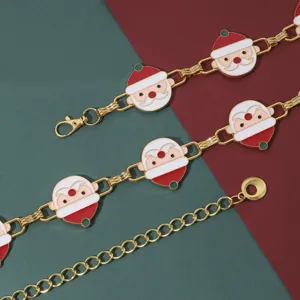 Vista detallada de la cadena de cintura de metal de Papá Noel con dijes de esmalte en rojo y blanco.
