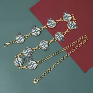 Cadena de cintura de metal dorado con colgantes de globo de esmalte azul y blanco y lazos.