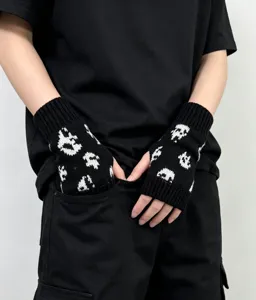Gants tricotés noirs et blancs sans doigts avec motif de crâne effrayant pour hiver.