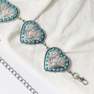 Detalle de cerca de cadena de cintura corazon metal etnico vintage con cuentas turquesas.