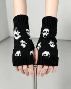 Gros plan sur les gants sans doigts en tricot noir et blanc avec motif tête de mort.