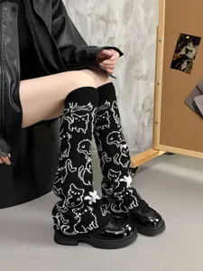 Knit leg warmers detail featuring black and white cat pattern, cozy winter fashion.
