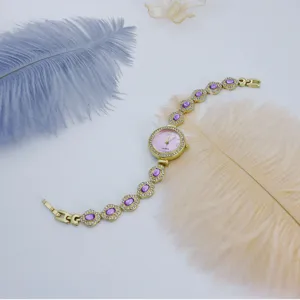 Vintage gouden quartz dameshorloge met paarse stenen en strass armband detailweergave mooi