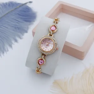 Detailopname van vrouwen luxe quartz horloge met strass wijzerplaat en roze kristallen hartarmband.