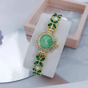 Close-up detail of women luxury quartz watch featuring green leaf gemstones and crystal dial.