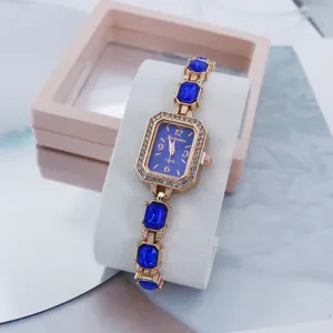 Elegante goldfarbene Damen Quarzarmbanduhr mit blauem Zifferblatt und funkelnden Kristallsteinen.