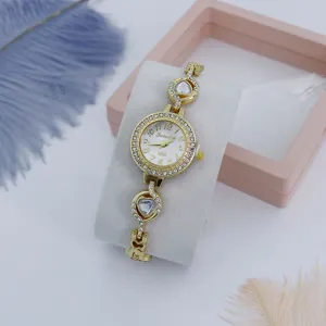Gedetailleerde close-up van een gouden dameshorloge met strass-rand en charmante hartarmband.