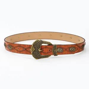 Detailed shot of vintage western embossed PU leather belt with ornate metal buckle and studs.
