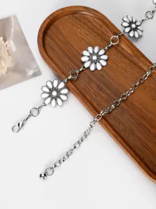 Chaîne de taille en métal argenté avec pendentifs fleurs blanches et mousqueton.